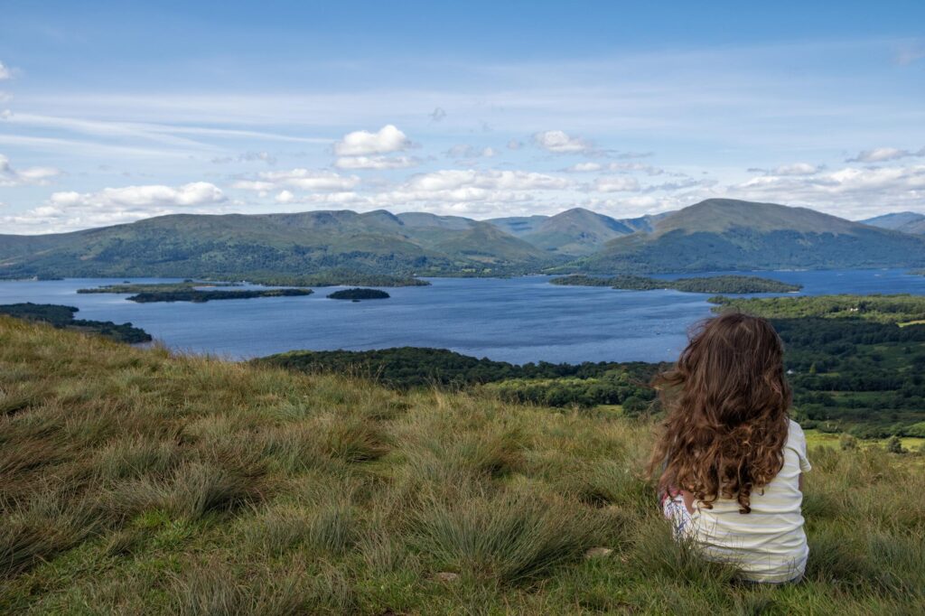 young girl sitting on a hill in Scotland 