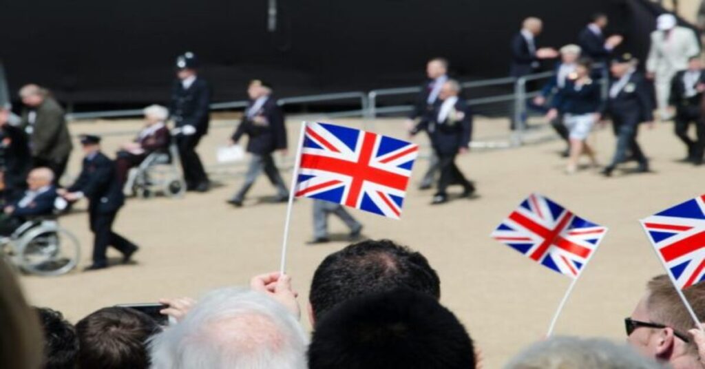 union jack flags being waved to people arriving in the uk