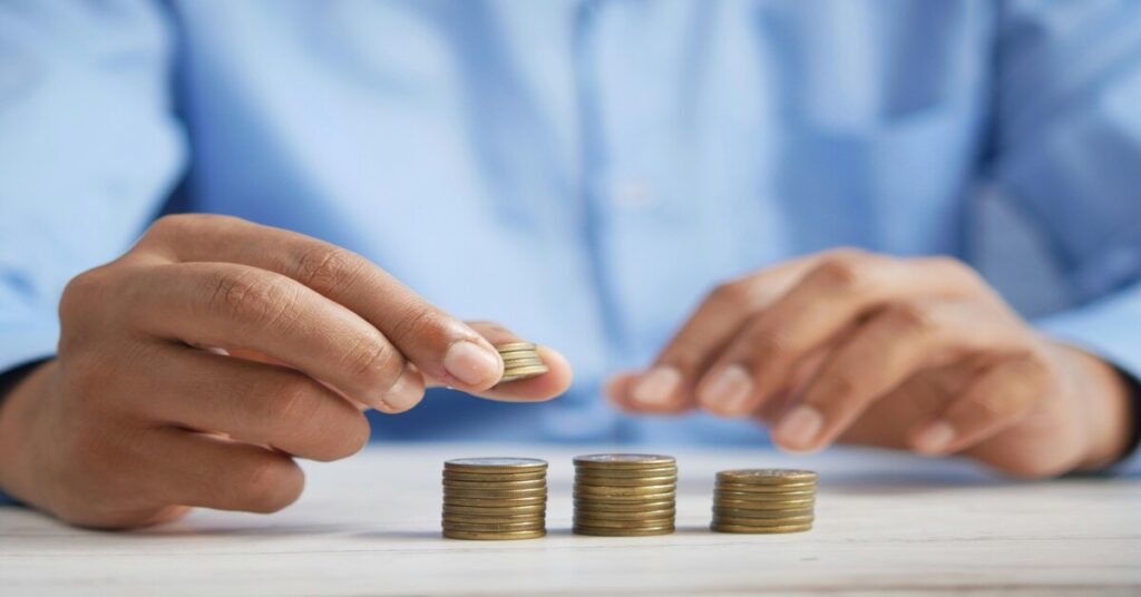 Person counting pound coins while learning about banking in the UK